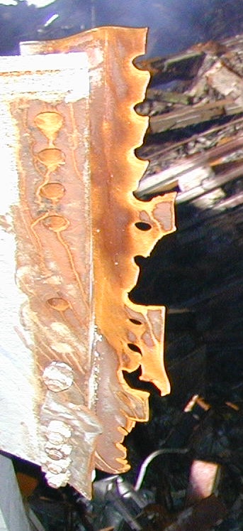 Close-up view of steel beam showing extreme erosion with sharp boundary, adjacent steel remaining relatively intact
